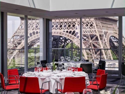 بولمان باريس برج إيفل في باريس: غرفة طعام مع طاولة وبرج ايفل