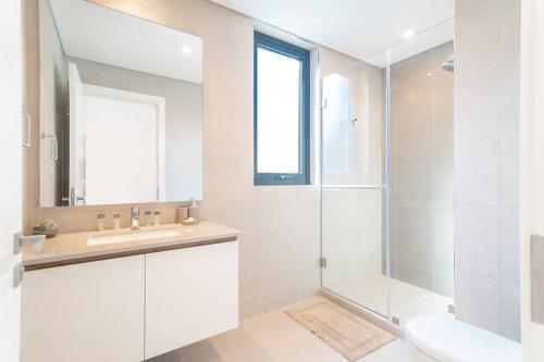 y baño blanco con lavabo y ducha. en Luxurious 3 BR with Maid Room in Arabian Ranches 2 en Dubái