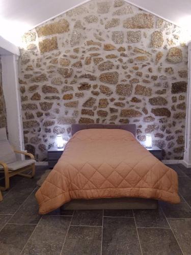 a bed in a room with a stone wall at Cottage Aldeia Da Serra - historic areas of Portugal in Celorico da Beira
