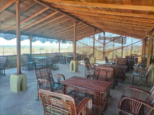 a group of tables and chairs in a pavilion at Sunset Camp in Dār as Salām