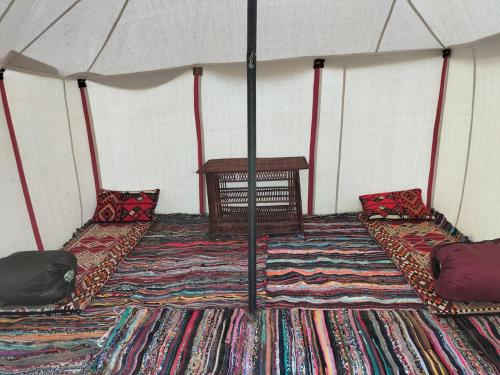 a room with two beds and a table in a tent at Sunset Camp in Dār as Salām