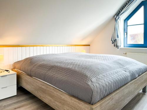 1 cama grande en un dormitorio con ventana en Feriendorf Papillon Wohnung 03-5, en Boltenhagen