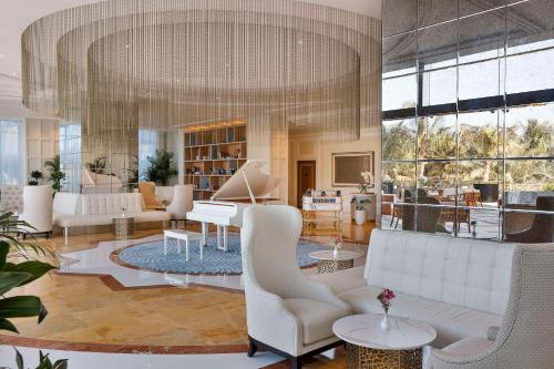 uma sala de estar com mobiliário branco e um grande lustre em Waldorf Astoria Ras Al Khaimah em Ras al-Khaimah