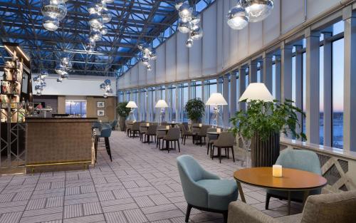 un vestíbulo con mesas y sillas en un edificio en DoubleTree By Hilton Moscow - Vnukovo Airport Hotel, en Vnukovo