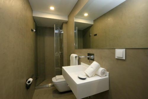 a bathroom with a sink and a toilet and a mirror at Charm Flats in Lisbon