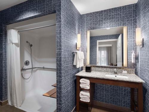 a bathroom with a shower and a sink and a mirror at Homewood Suites Columbus - Airport in Columbus