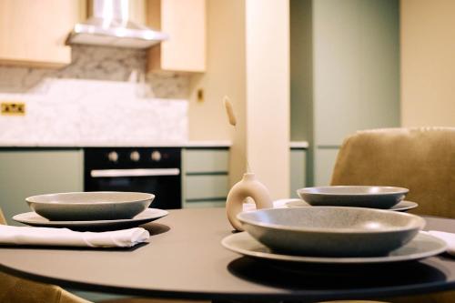 a table with three bowls on top of it at Nest Serviced Apartments in Bedford