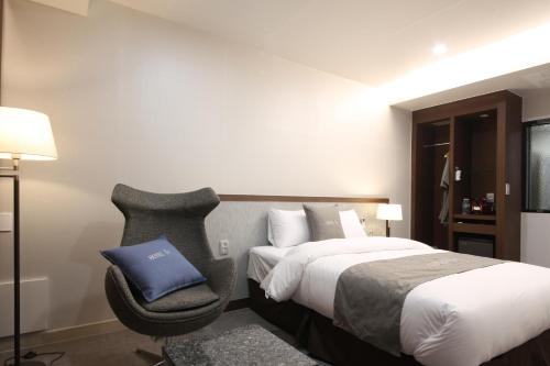 a hotel room with a bed and a chair at Hotel J's in Gumi