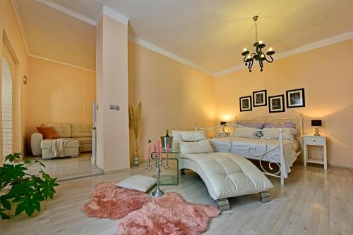 a bedroom with a bed and a couch and a chandelier at Apartments Villa Herak in Poreč