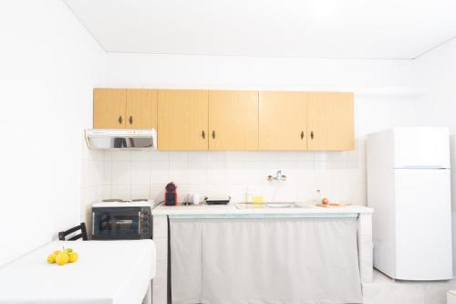 a kitchen with a sink and a refrigerator at Kineta Seaside Summer Apartments in Kineta