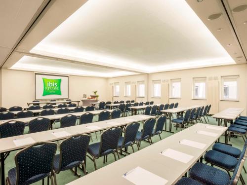 una sala de conferencias vacía con mesas y sillas en ibis Styles Warszawa West, en Mory