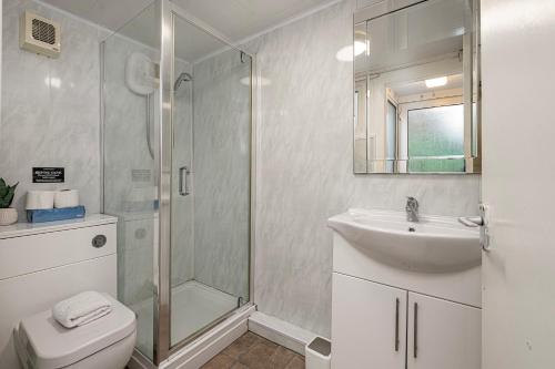 ein Bad mit einer Dusche, einem WC und einem Waschbecken in der Unterkunft Cheerful 2 bedroom cottage with garden in Llanelltyd