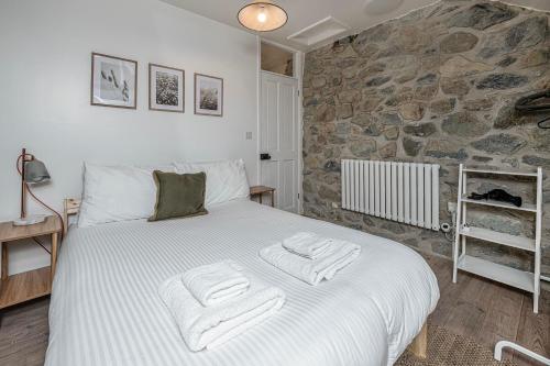 a bedroom with a large bed with towels on it at Cheerful 2 bedroom cottage with garden in Llanelltyd