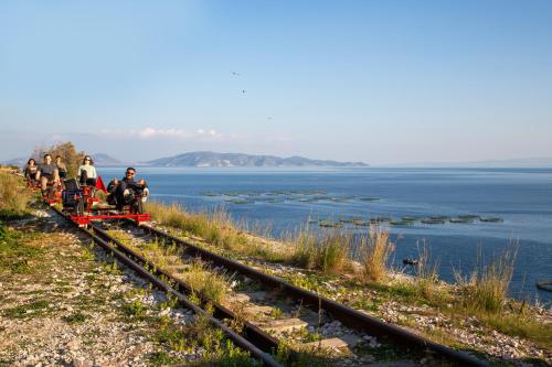 a group of people riding a small train on the tracks at Kineta Seaside Summer Apartments in Kineta