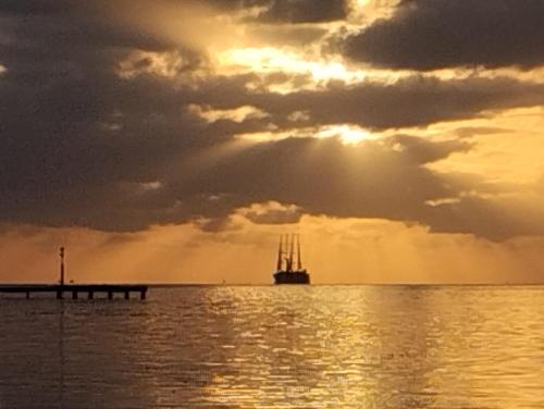 a ship in the ocean under a cloudy sky at Tema'e Beach House in Temae