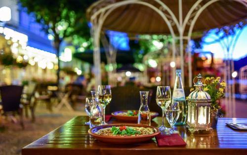 a table with wine glasses and a bowl of food on it at Bellevue Rheinhotel in Boppard