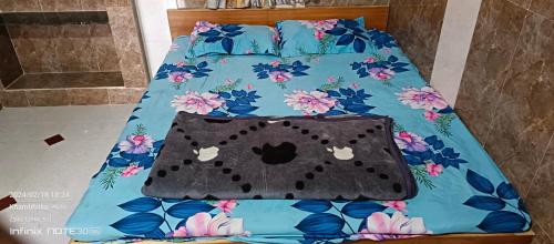 - un lit avec une couverture et un chat dans l'établissement Om Bungalow, à Dwarka