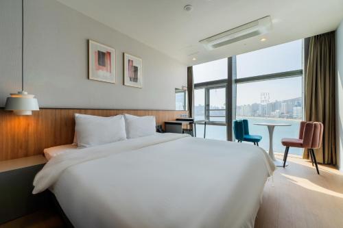 a hotel room with a large bed and a table at Gray 193 Hotel in Busan