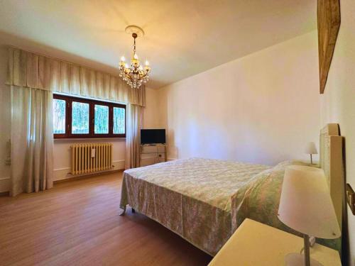 1 dormitorio con cama y lámpara de araña en Appartamento Il Fiocco by Nicola Real Estate, en Lucca