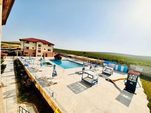 une grande piscine avec des chaises et un bâtiment dans l'établissement Pensiunea Fabian, à Jurilovca