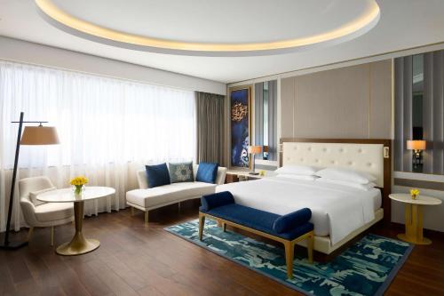 Grand Hyatt Al Khobar Hotel and Residences في الخبر: غرفة نوم مع سرير وغرفة معيشة