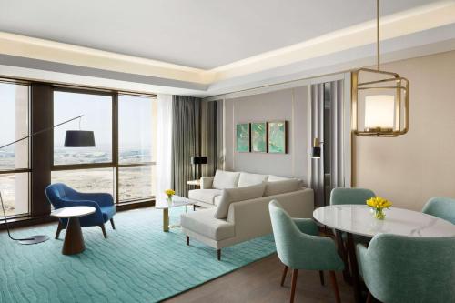 Grand Hyatt Al Khobar Hotel and Residences في الخبر: غرفة معيشة مع أريكة وطاولة وكراسي