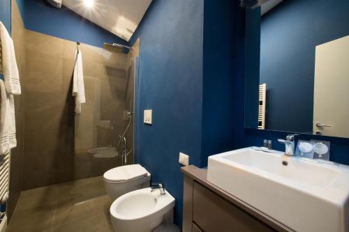 TA - One bedroom luxury apartment in the fashion district في فلورنسا: حمام ازرق مع مرحاض ومغسلة