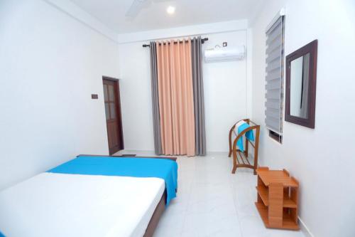 a bedroom with a bed and a chair in it at Hide Hiriketiya Villa in Dickwella