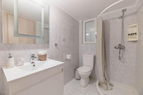 a bathroom with a toilet and a sink and a shower at The HostMaster Beachside Retreat in Vari