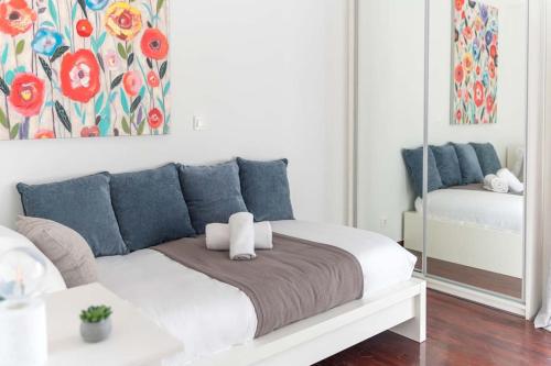 a white bed with blue pillows in a room at The HostMaster Beachside Retreat in Vari