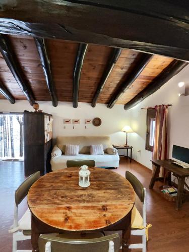 a room with a wooden table and a bed at La Casa Gran in Castielfabib