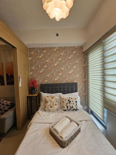 ein Schlafzimmer mit einem Bett mit einer weißen Decke und einem Kronleuchter in der Unterkunft The Metro Haven in Manila