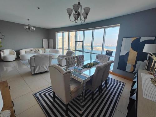 a living room with a table and chairs and a couch at Luxury Corniche Apartment in Sharjah