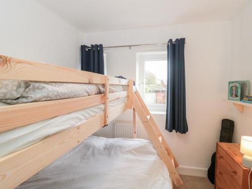 a bedroom with two bunk beds and a window at Bluebird Cottage in Castle Cary