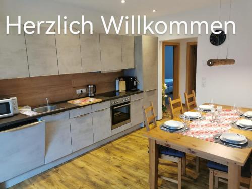 a kitchen with a wooden table with chairs and a dining room at Apart Emilia in Schönwies