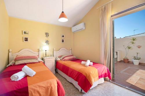 a bedroom with two beds and a large window at Villa Valdelagrana in El Puerto de Santa María