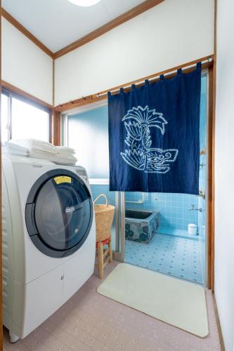 a washing machine in a bathroom with a shower at Shachihoko 海辺の一棟貸切ヴィラ しゃちほこ in Imari