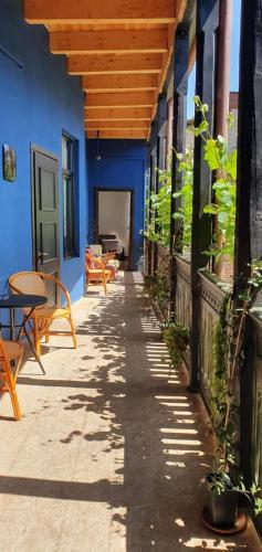 a patio with a blue building with a wooden ceiling at Vintage room in Tbilisi City