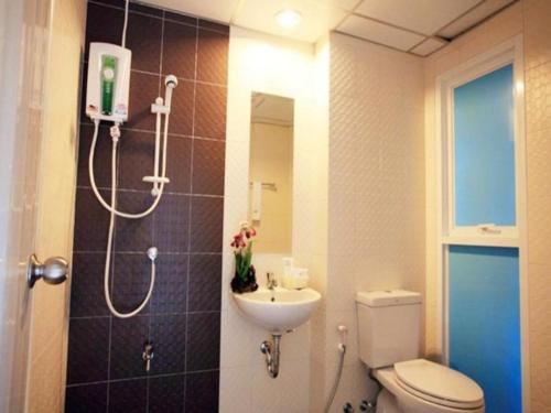 ein Bad mit einer Dusche, einem WC und einem Waschbecken in der Unterkunft Similan Mansion in Bangsaen