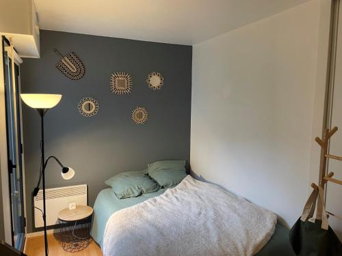 - une chambre avec un lit et un mur avec des assiettes dans l'établissement 2 pièces Asnières Idéal JO 2024, à Asnières-sur-Seine