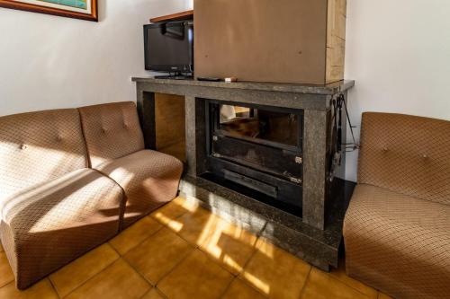 a living room with two chairs and a fireplace at Can Pons De Dalt Casa rural a la Selva in Girona
