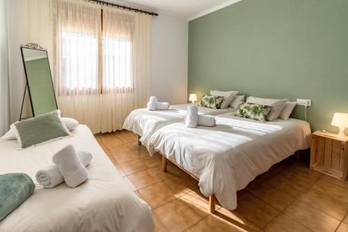 una camera con tre letti con asciugamani di Can Pons De Dalt Casa rural a la Selva a Girona
