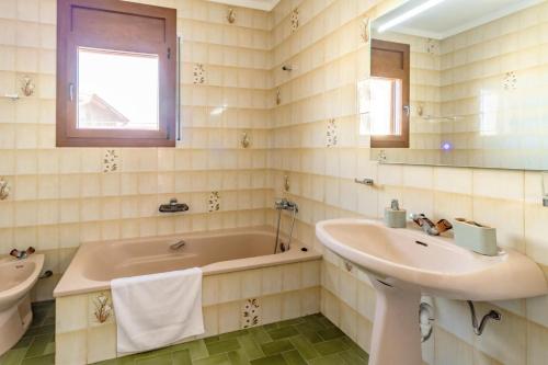 a bathroom with a tub and a sink and a bath tub at Can Pons De Dalt Casa rural a la Selva in Girona