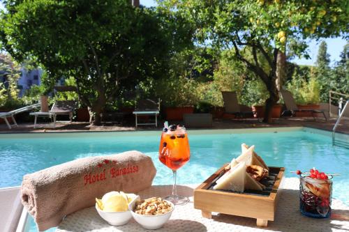 a tray of food and a drink next to a pool at Hotel Paradiso in Castellammare di Stabia