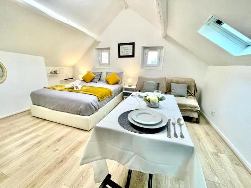 1 dormitorio con cama, mesa y sofá en Studio cosy à Meaux, en Meaux