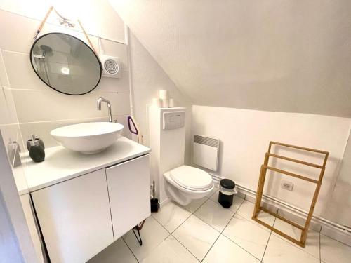 Baño blanco con lavabo y aseo en Studio cosy à Meaux, en Meaux