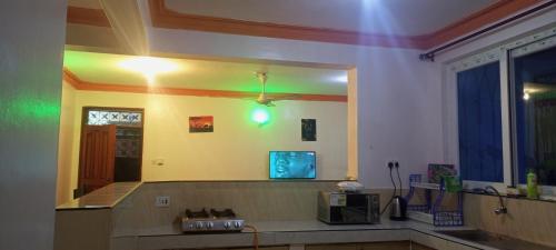 a kitchen with a mirror and a tv on the wall at Lovely and spacious apartment with swimming pool in Mtwapa