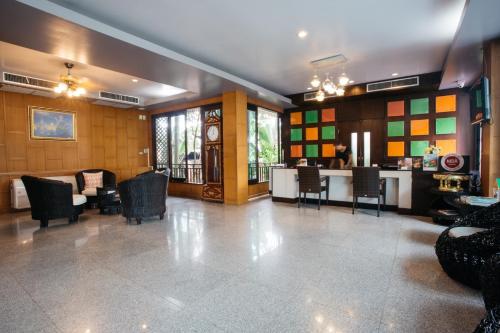 a lobby with chairs and a table and a clock at Diamond Park Inn Chiangrai & Resort in Chiang Rai