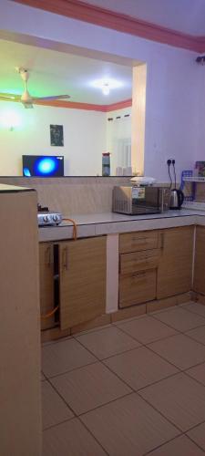 a kitchen with a counter top with a microwave at Lovely and spacious apartment with swimming pool in Mtwapa