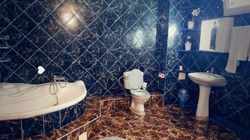 łazienka z wanną, toaletą i umywalką w obiekcie Pensiunea King w mieście Timişoara